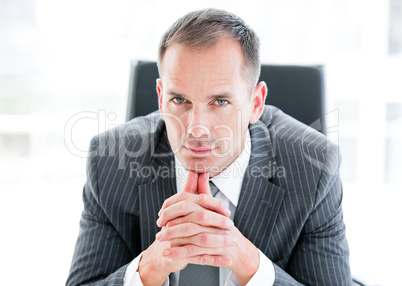 Serious businessman looking at the camera sitting