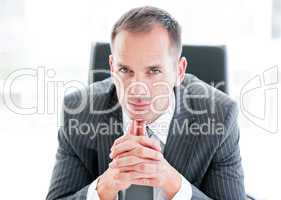 Serious businessman looking at the camera sitting