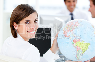 Smilling businesswoman holding a globe