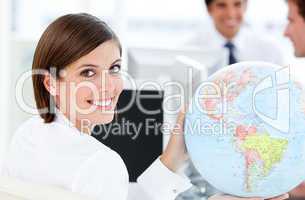 Smilling businesswoman holding a globe