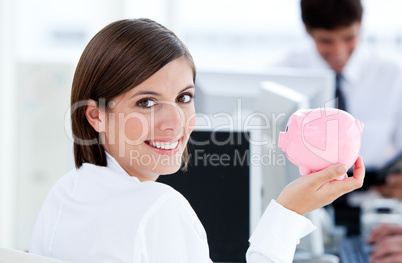 Happy businesswoman holding a piggybank
