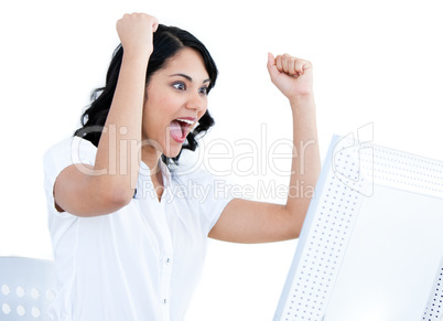 Enthousiastic businesswoman punching the air in front of her com