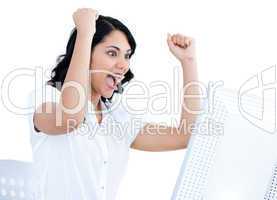 Enthousiastic businesswoman punching the air in front of her com