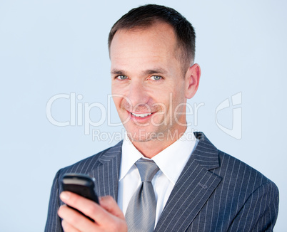 Confident businessman sending a text with his  phone