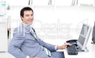 Smiling young businessman working at a computer