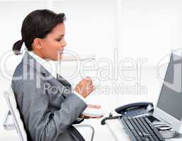 Attractive businesswoman drinking a coffe while working at a com