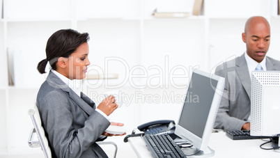 Confident businesswoman drinking a coffe while working at a comp