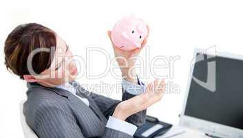 Upset businesswoman holding a piggy-bank