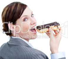 Glowing businesswoman eating a chocolate eclair