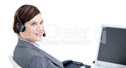 Confident businesswoman with headset on sitting at her desk