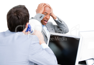 Angry young businessman yelling through a megaphone