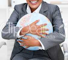 Close-up of a smiling businesswoman holding a terrestrial globe