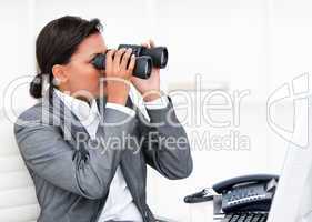 Self-assured businesswoman looking through binoculars