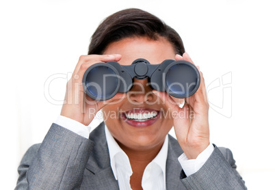 Assertive businesswoman looking through binoculars
