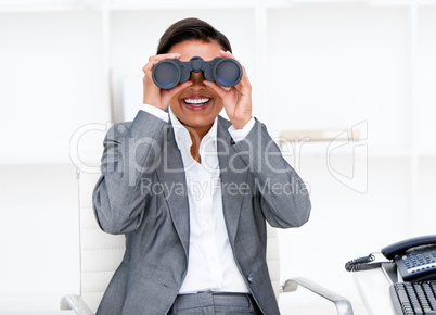 Jolly businesswoman looking through binoculars