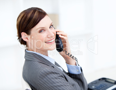 Confident businesswoman on phone sitting at her desk
