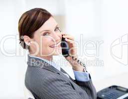 Confident businesswoman on phone sitting at her desk