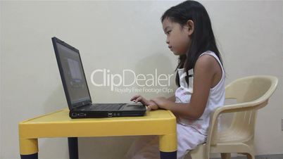 A child reading playing on a laptop