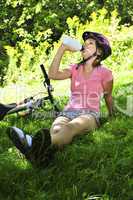 Teenage girl resting in a park with a bicycle
