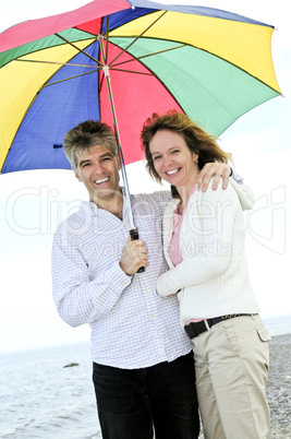 Happy mature couple with umbrella