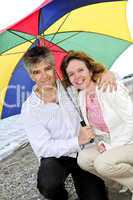 Happy mature couple with umbrella
