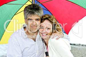 Happy mature couple with umbrella