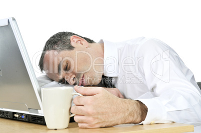 Businessman asleep at his desk on white background