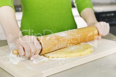 Hands with rolling pin and cookie dough
