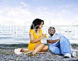 Happy couple having wine on beach