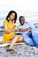 Happy couple having wine on beach