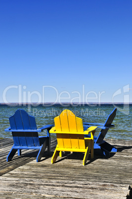 Chairs on wooden dock at lake