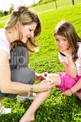 Mother putting bandage on child