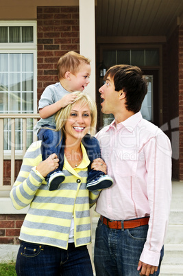 Happy family in front of home