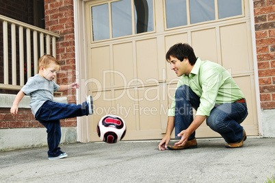 Father and son playing soccer