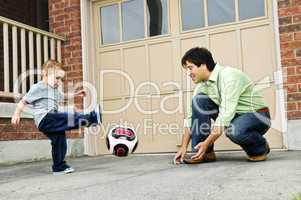 Father and son playing soccer