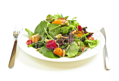 Plate of green salad on white background