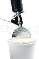 Tub of vanilla ice cream with a scoop