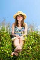 Young girl sitting in meadow