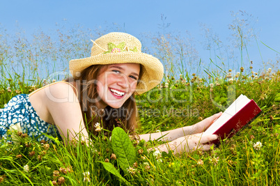 Young girl reading book in meadow