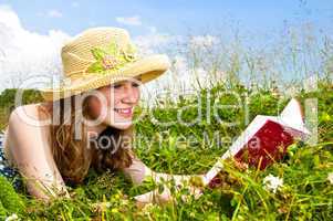 Young girl reading book in meadow