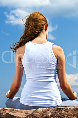 Young girl meditating outdoors