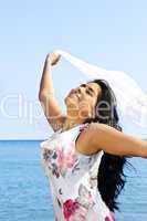 Beautiful young woman at beach with white scarf