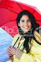 Beautiful young woman in raincoat with umbrella