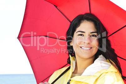 Beautiful young woman in raincoat with umbrella