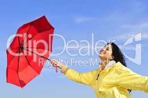 Beautiful young woman in raincoat with umbrella