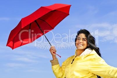 Beautiful young woman in raincoat with umbrella
