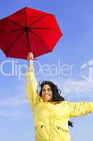 Beautiful young woman in raincoat with umbrella