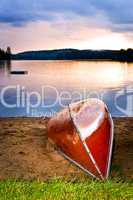 Lake sunset with canoe on beach