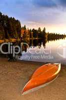 Lake sunset with canoe on beach