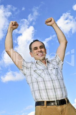 Happy man raising hands in victory